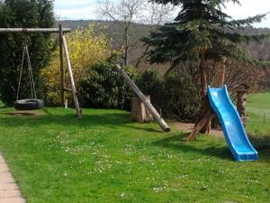 um parque infantil com um escorrega azul e baloiços em Ferienwohnungen Zeltnerhof em Breitenbrunn