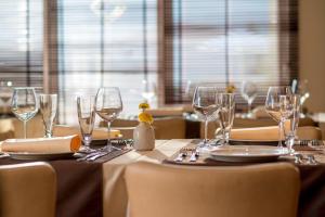 una mesa con copas de vino y platos en ella en Hotel WGrand, en Petrovac na Moru