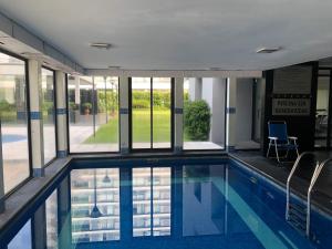 a swimming pool in a building with windows at Edificio Jardines del Country Piso 19 in Punta del Este