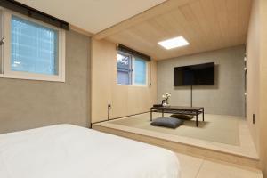 1 dormitorio con cama, mesa y TV en Slow Stay DA, en Seúl