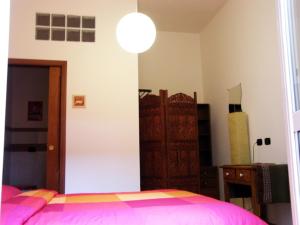 Schlafzimmer mit einem Bett mit rosa Tagesdecke in der Unterkunft Breakfast In Bed in Rom