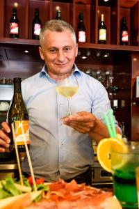 un hombre sosteniendo una copa de vino blanco en Dune Agriturismo, en Eraclea Mare