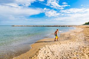 Dune Agriturismo في ايراكليا ماري: رجل يقف على شاطئ قريب من الماء