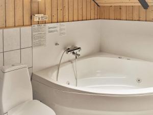 a bathroom with a bath tub and a toilet at 8 person holiday home in V ggerl se in Marielyst