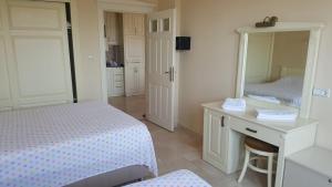 a bedroom with a bed and a desk and a mirror at Alanya Goldcity one bedroom villa in Kargicak +8 photos