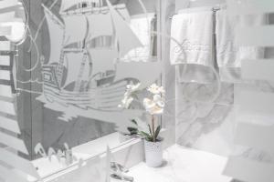 a bathroom with a sink and a mirror and flowers at Adrina Beach Hotel in Panormos Skopelos