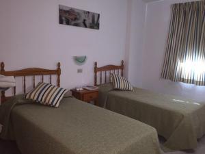 Habitación de hotel con 2 camas y ventana en Apartment on Playa Las Vistas, en Arona