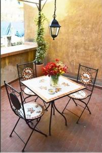 een tafel en stoelen met een vaas met bloemen erop bij Breakfast In Bed in Rome