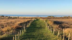 a fence in a field with the ocean in the background at Trafalgar Polo Club in El Palmar