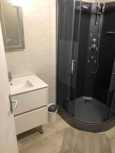 La salle de bains est pourvue d'une douche et d'un lavabo. dans l'établissement Joli appartement à Murat proche du Lioran Cantal, à Murat