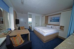 a hotel room with a bed and a desk at Hotel Quisisana & Appartements Quisi in Helgoland