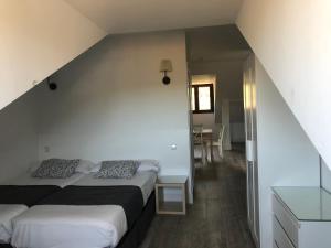ラ・グランハ・デ・サン・イルデフォンソにあるCasa Valsainのベッドルーム1室(ベッド2台、テーブル、階段付)