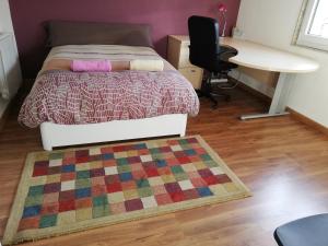 a bedroom with a bed and a desk and a rug at El Lagar in Aller