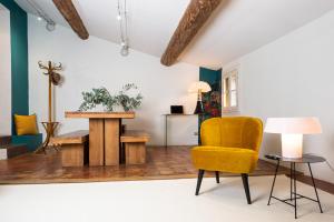 un salon avec une chaise jaune et une table dans l'établissement Maison Dauphine, à Aix-en-Provence