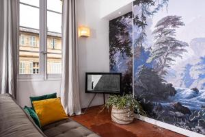 un salon avec un canapé et une grande peinture murale dans l'établissement Maison Dauphine, à Aix-en-Provence