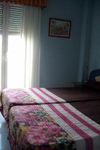 a bedroom with a bed with a quilt on it at Hospedaje Argoños in Argoños