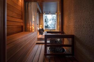 una mujer sentada en una habitación con ventana en Lapland Hotels Sky Ounasvaara, en Rovaniemi