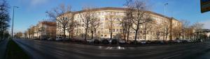 duży budynek z samochodami zaparkowanymi przed nim w obiekcie Hostel VITA Berlin w Berlinie