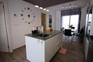 a kitchen with a sink and a clock on the wall at Apartamento Lopagan Entremares in Lo Pagán