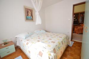 1 dormitorio con 1 cama y una foto en la pared en Apartment Franka, en Mali Lošinj