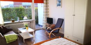 a living room with a couch and a tv and a table at Appartementhaus Martel - Adults Only in Travemünde