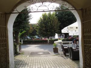 an archway leading to a patio with tables and chairs at Ferdinand Apartments in Mediaş