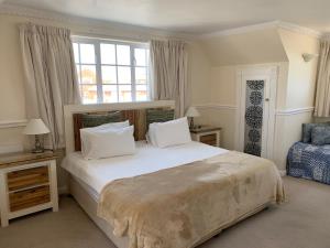 Un dormitorio con una gran cama blanca y una ventana en Birkenhead Manor, en Bloubergstrand