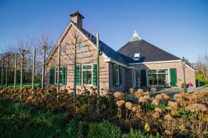 una casa con un mazzo di fiori davanti di T'hûs bed & breakfast a Katlijk