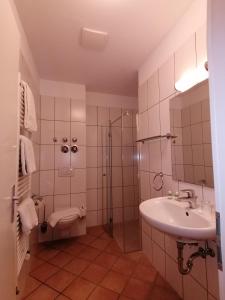 uma casa de banho com um lavatório, um chuveiro e um WC. em Hostel VITA Berlin em Berlim