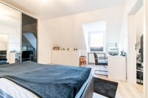 a bedroom with a large bed and a kitchen at Private Apartment in Hannover