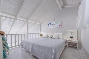 a white bedroom with a bed and a white ceiling at Adrina Beach Hotel in Panormos Skopelos