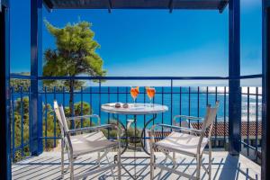 a table and chairs on a balcony with a view of the ocean at Adrina Beach Hotel in Panormos Skopelos