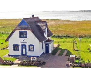 a small house in the middle of a field at Reetdachhaus Windsbraut in Breege
