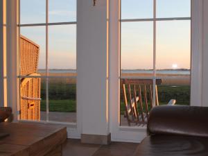 a room with a window with a view of the ocean at Reetdachhaus Windsbraut in Breege +4 photos