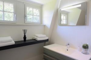 a white bathroom with a sink and a mirror at Domaine des Bruyères in Sains-en-Amiénois +35 photos