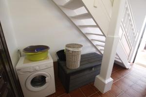 a laundry room with a washing machine and stairs at Alojamiento Vacacional con balcón La Vela in Puerto Calero