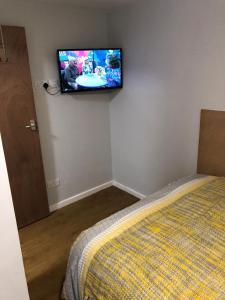 a bedroom with a bed and a flat screen tv on the wall at 228 Cinderhill Road in Nottingham