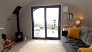 a living room with a couch and a large glass door at The Bee Pods in Rossnowlagh