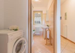 a laundry room with a washing machine and a bathroom at Palma Romantic Dream in Perledo