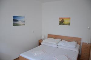 a bedroom with a bed with two pictures on the wall at Chata Horec in Štrba