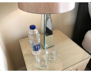 eine Flasche Wasser auf einem Tisch neben einer Lampe in der Unterkunft Queens Road Rental - Winchester Accommodation in Winchester