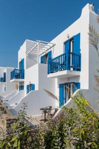 a row of white buildings with blue balconies at Vienoula's Garden Hotel in Mýkonos City