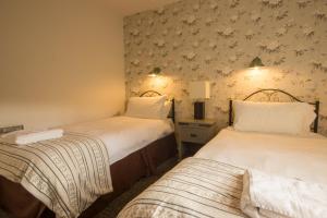 Un pat sau paturi într-o cameră la Eyam Cottage - Darwin Lake Holiday Village