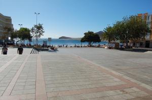 a street in front of a beach with people walking at APARTAMENTOS LOS LAURELES in El Médano