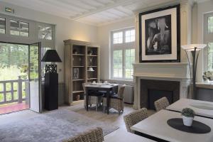 a living room with a fireplace and a table and chairs at Domaine des Bruyères in Sains-en-Amiénois