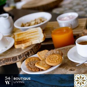 a table with a plate of bread and a cup of coffee at Fiftyfour West Boutique Living in Għarb