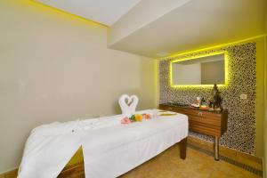a bedroom with a white bed with a dresser and a mirror at Oran Hotel in Istanbul