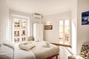 um quarto branco com uma cama e 2 janelas em Cavour Attic with terrace em Roma