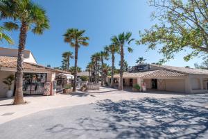 a street in front of a building with palm trees at Marino Mobilhomes in Grimaud