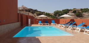 basen z leżakami i grupą dzieci w obiekcie Villa Rustica Gran Canaria w mieście Maspalomas